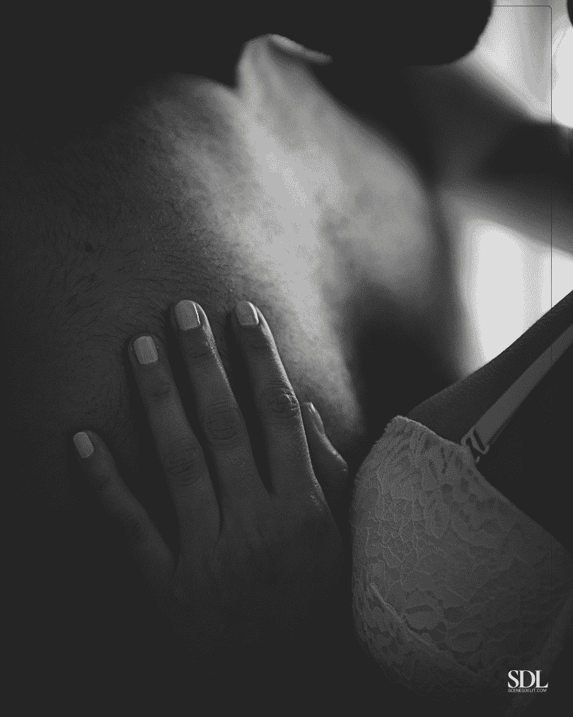 Le torse d'un homme avec une femme en soutien gorge qui pose sa main dessus